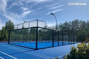 Cancha de pádel panorámica con cerramiento de vidrio y superficie de césped artificial